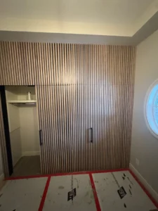 Completed vertical slat wall with three concealed doors