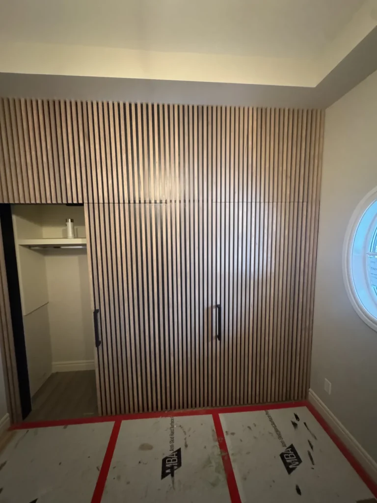 Completed vertical slat wall with three concealed doors