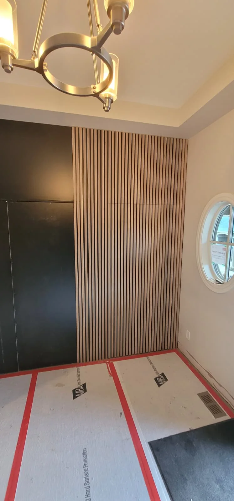 A concealed door aligned through continuous wood slat paneling